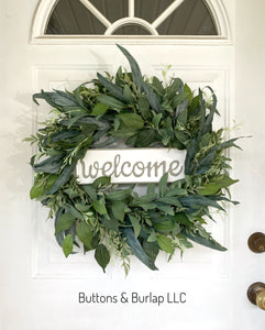 Greenery wreath with metal welcome sign